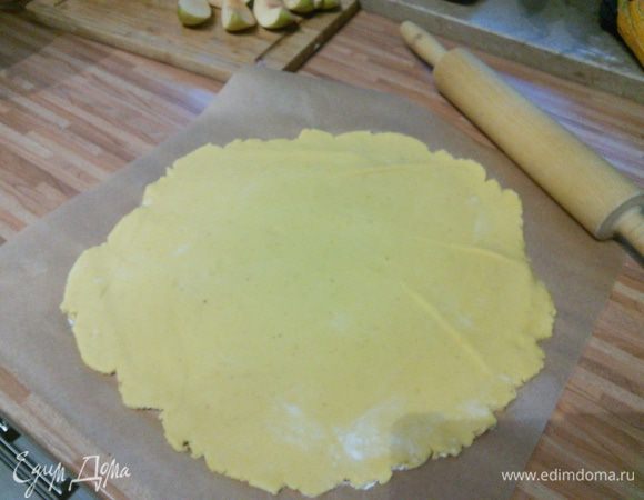 Духовку разогреть до 180°С. Тесто раскатать на пергаментной бумаге в круг. 