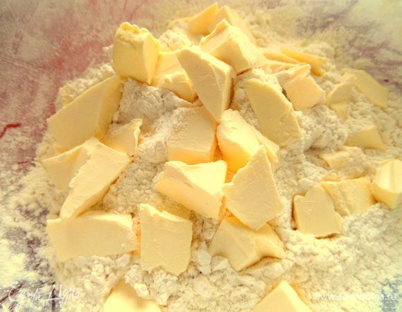 В муку нарезать кусочки холодного масла.