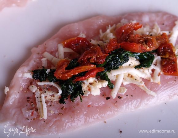 Отбитое куриное филе немного солим, перчим, выкладываем на него сыр, шпинат и вяленые томаты.