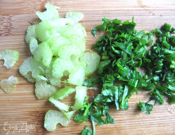 Морковь помыть, почистить, натереть на крупной терке, прожарить 1 минуту на сковороде на оливковом масле. Сельдерей нарезать тонкими пластинами. Лук-резанец и петрушку помыть, мелко нарезать. 