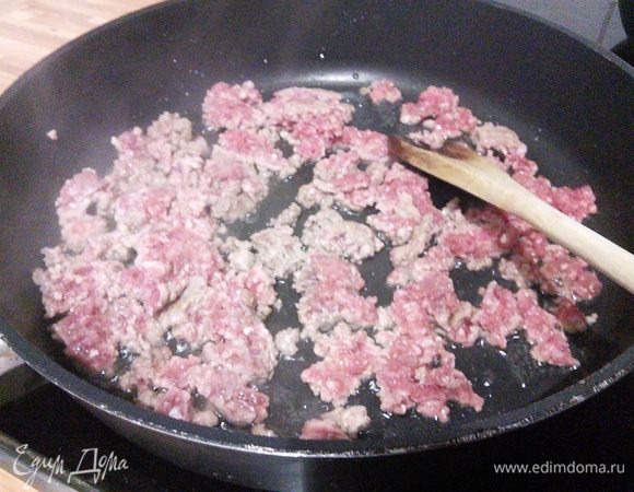 Первым делом через дуршлаг слить жидкость с фасоли и кукурузы, промыть под холодной водой. На сковороде разогреть масло, обжарить фарш, раздрабливая его с помощью деревянной ложки, чтобы не было крупных комочков. 