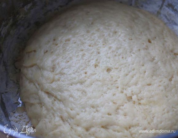 Через час обомните поднявшееся тесто и оставьте его еще на полчаса. Пока тесто подходит второй раз, можно заняться начинкой: нарезать копчености, натереть сыр и измельчить орехи. Яйца отварить и тоже натереть на терке. Смешайте все ингредиенты начинки и добавьте сметану.