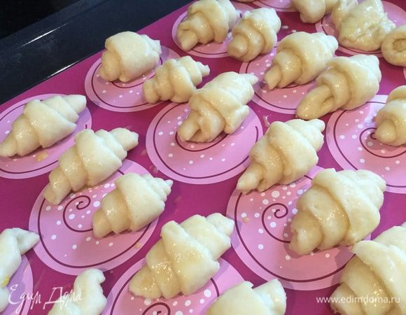 Выложите рогалики на противень застеленный бумагой для выпечки или силиконовым ковриком. (У меня получилось на 2 противня) Духовку разогрейте до 190°С.