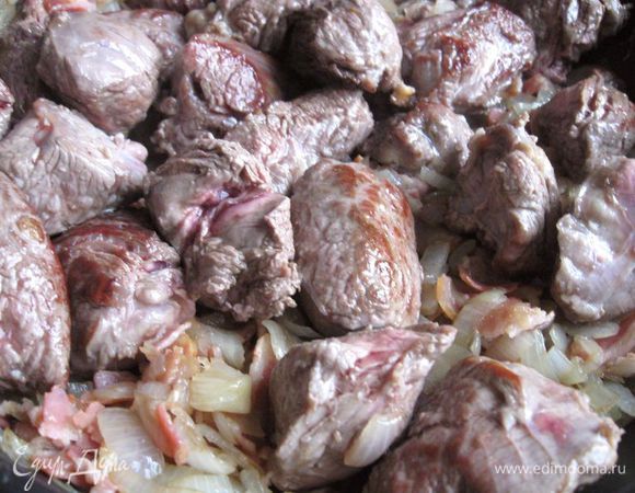 Мясо обжарить отдельно на раскаленной сковороде со всех сторон на оливковом масле. На сковороде мясо должно лежать в один слой, иначе температура обжаривания будет недостаточной, и из мяса выделится сок. 