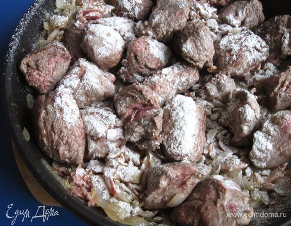 Соединить содержимое двух сковород: той, где находится лук и бекон, и той, где находится мясо, присыпать мукой. 