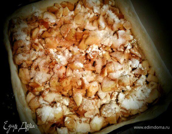 Раскатываем тесто по размеру противня. Быстро нарезаем произвольным образом яблоки, сверху посыпаем сахаром, корицей и крахмалом. Сверху укрываем пластом теста. Защипываем края, делаем отверстия для выхода пара. Смазываем яйцом, выпекаем 25 — 30 минут при 180°С.