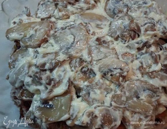 Шампиньоны смешать с майонезом. Но добавлять немного, т.к. грибы и так готовились на масле. Выложить их сверху моркови и лука.