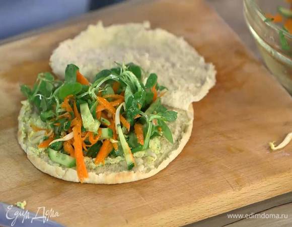 Питу прогреть на сухой сковороде с двух сторон, затем разрезать вдоль пополам, не прорезая до конца, так чтобы получился карман, смазать одну сторону внутри 1 ст. ложкой хумуса и выложить заправленные овощи.