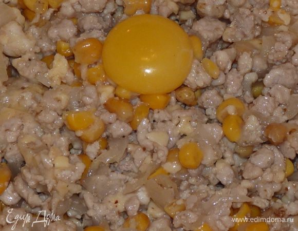 Добавить соль, молотый кориандр. Сыр натереть на крупной терке, половину добавить в фарш. Добавить желток и кукурузу. Перемешать.