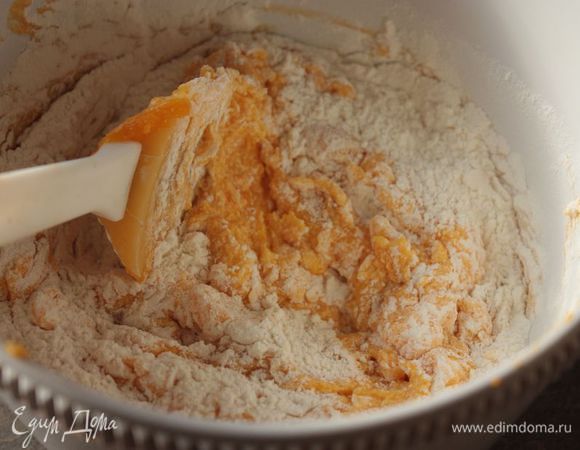 Добавьте в смесь тыквенное пюре и апельсиновые корочки, нарезанные кубиками. В этот раз я добавила в тесто еще и курагу, получилось очень вкусно!
Просейте муку с разрыхлителем прямо в смесь и замесите тесто. Оно получится очень нежным и гладким.