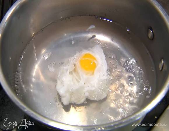 Приготовить яйцо пашот: в небольшой кастрюле вскипятить 500 мл воды, добавить 1 ч. ложку уксуса, с помощью венчика сделать маленький водоворот и в центр воронки вылить яйцо. Убавить огонь и варить 2–3 минуты, затем шумовкой выложить яйцо на бумажное полотенце. Так же приготовить второе яйцо.