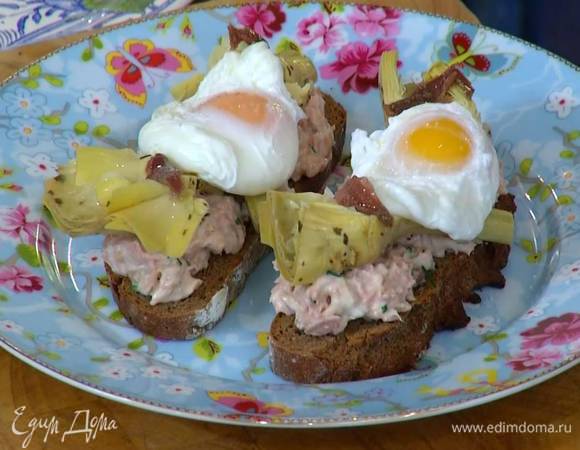 На обжаренный хлеб выложить соус из тунца, сверху поместить артишоки и яйцо пашот, желтки посолить и украсить брускетты оставшимися анчоусами.