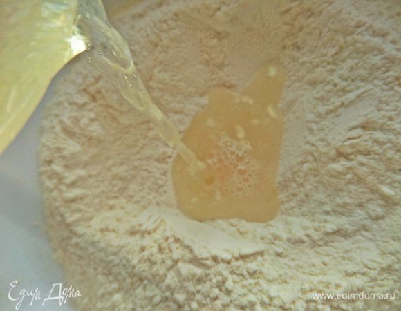 Смешать муку с сухими дрожжами, если так написано на упаковке. Воду смешать с солью, сахаром, маслом и вылить в ямку в муке. В оригинале воды нужно 170 мл, но мне потребовалось чуть больше.