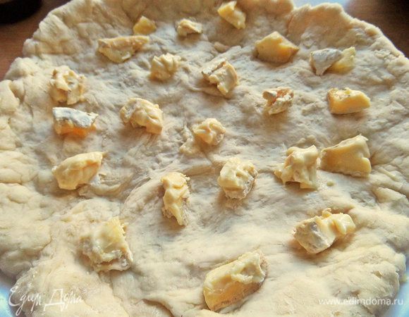 Растянуть в пласт и положить для начинки сыр кусочками. 