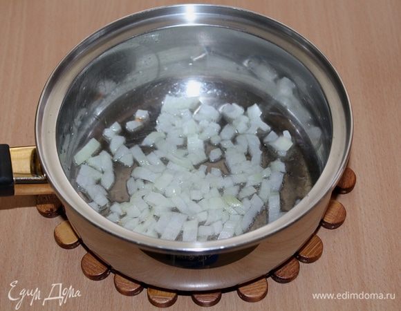 Разогреть в толстостенной кастрюле растительное масло и обжарить в нем до прозрачности мелко нарезанный лук.
