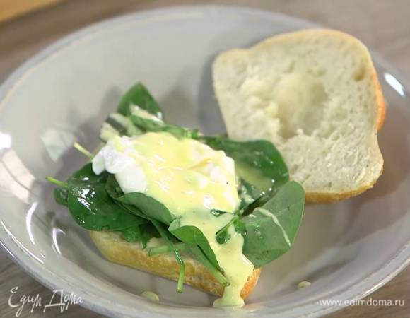 Булочку разрезать вдоль пополам, одну половинку смазать соусом голландез, выложить шпинат и яйцо пашот, сверху полить все соусом и надрезать желток.