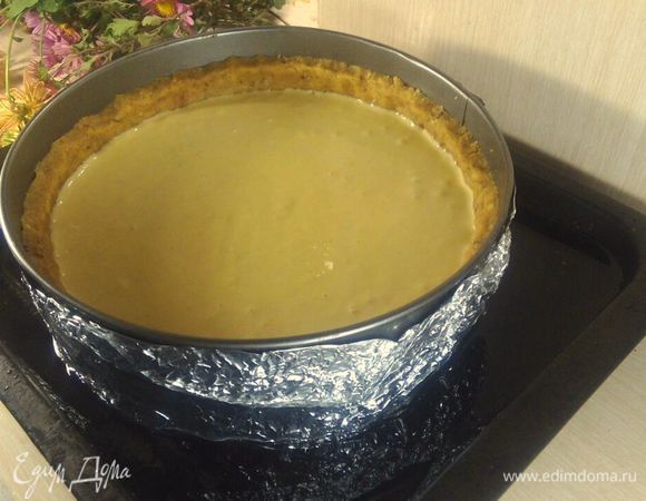 Достаем наш корж из холодильника, заливаем туда начинку. Такой чизкейк можно выпекать и без водяной бани, но мне кажется, что именно благодаря ей он остается таким нежным. Поэтому я оборачиваю фольгой нашу форму, ставлю на противень, куда наливаю теплую воду. Ставим аккуратно в духовку на 160 — 170°С выпекаться примерно на час. Помним — чизкейк готов, когда еще серединка немного дрожит при прикосновении. 