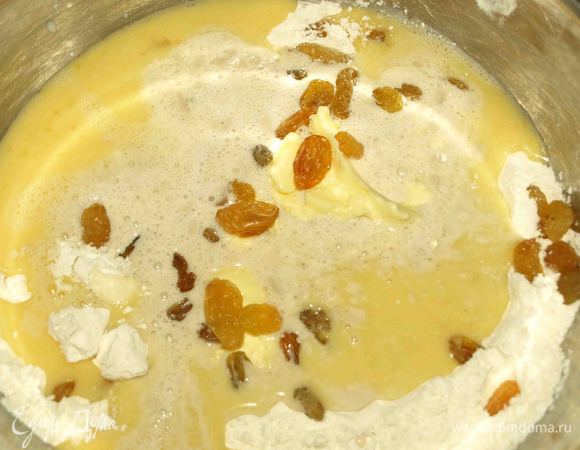 Добавляем размягченное масло и изюм.