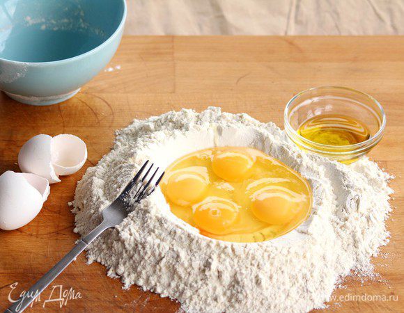 В муку вводим 4 яйца и разбиваем вилкой, делая замес.