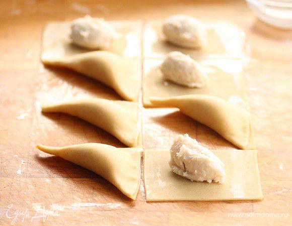 Чтобы слепить треугольники тесто по краю смазываем водой и слепляем края.