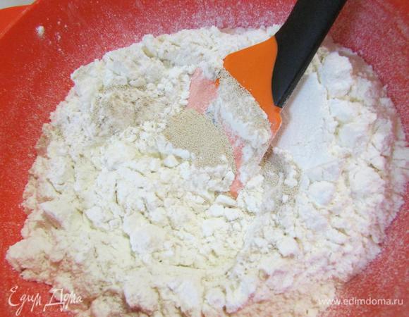Муку просеять и хорошо перемешать с сухими дрожжами.