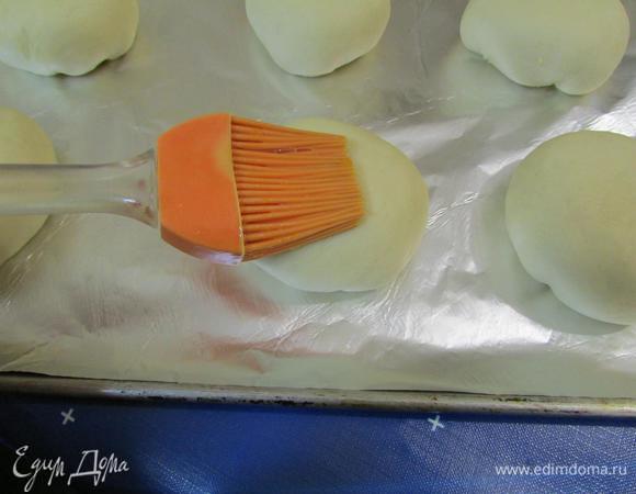 Яичный желток смешать с 1 столовой ложка молока. С помощью кулинарной кисти смазать булочки.