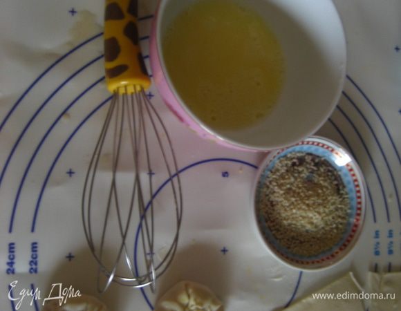 Соединенные концы наших квадратиков защипываем и прижимаем к середине. Смазываем взбитым яйцом и сверху посыпаем кунжутом.