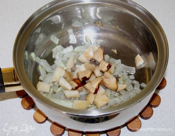 Лук мелко порезать и обжарить на оливковом масле до прозрачности. Затем добавить порезанные грибы, обжарить еще пару минут.