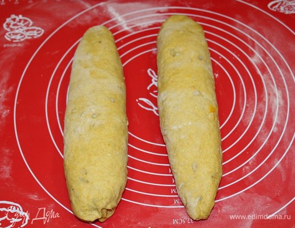 Подошедшее тесто слегка обмять, разделить на две равные части, сформировать продолговатые буханки. 