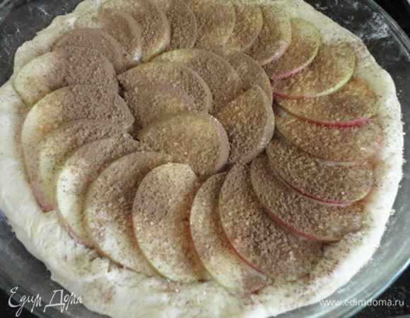 Для пирога яблоко очищаю от семян, нарезаю дольками. Форму смазываю растительным маслом. Тесто раскатать в круг, посыпать крахмалом, чтобы тесто не «мокрело» от свежих яблок, которые выкладываем чешуйкой, посыпаем корицей и коричневым сахаром.