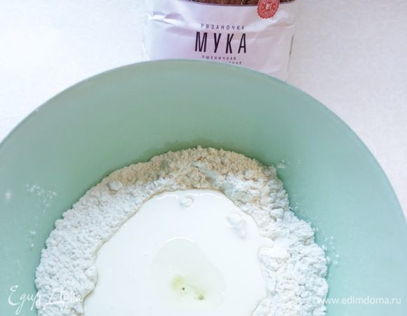 Сделать углубление в сухой смеси, влить кефир и растительное масло.