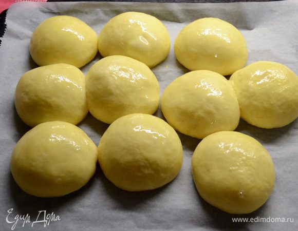 Духовку разогреть до 180°С. Перед выпечкой смазать булочки смесью из яйца и молока и выпекать в разогретой духовке примерно 20 минут. 