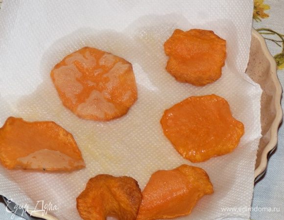 Тыквенные слайсы обмакнуть в смесь муки и крахмала. Жарить на раскаленном масле с двух сторон. Выложить на бумажное полотенце, чтобы впитался лишний жир.