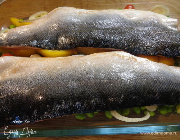 Выложить рыбу в форму поверх овощей, шкуркой вверх. И отправим в разогретую до 200°С духовку на 25 — 30 минут.