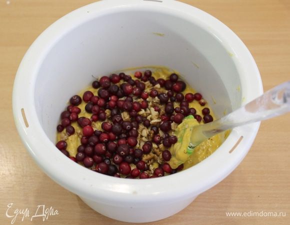 Всыпьте сухую мучную массу в яично-тыквенную смесь и размешайте. Добавьте клюкву и орехи.