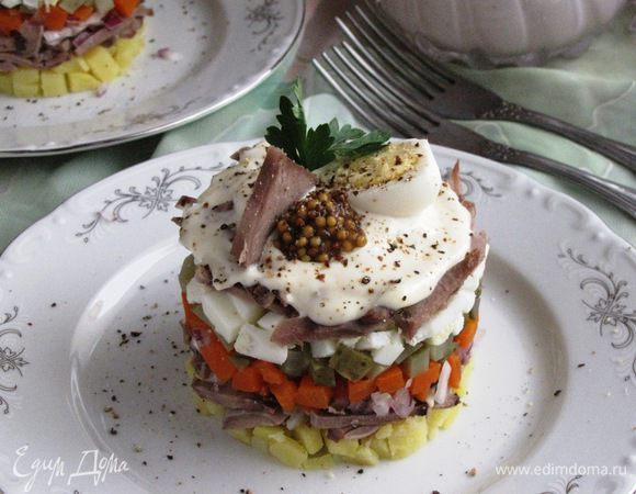 Снять сервировочное кольцо и украсить салат по своему желанию. Например, кусочком языка, перепелиным яйцом, петрушкой, зерновой горчицей. Сверху посыпать свежемолотым перцем.