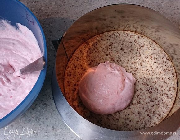 Вокруг бисквитного коржа установить контур. Выложить клубничный крем.