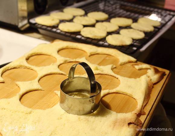 Бисквиты выкладываем на ровную поверхность, снимаем бумагу для выпечки и вырезаем кружочки.