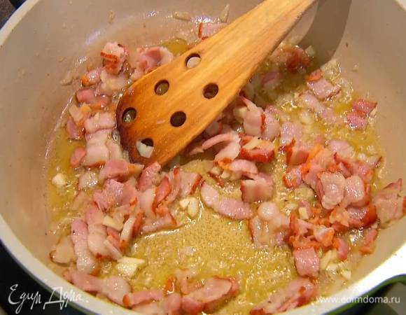 Бекон нарезать тонкими полосками, добавить к луку с чесноком, посолить, поперчить и обжарить до золотистого цвета.