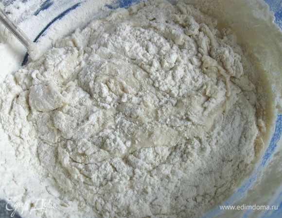 Начинать добавлять просеянную муку (частями, перемешивая), соль. 