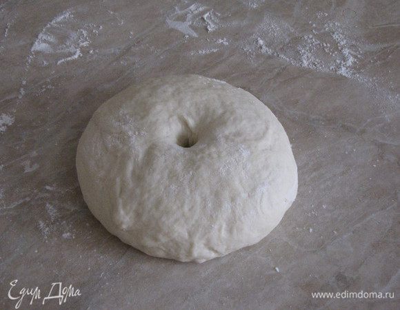 Тесто обмять и снова скатать в шар. Наметить в шаре центр, сделать дырку.