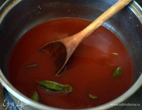 Ставим на огонь глубокую кастрюлю, вливаем томатный соус, добавляем примерно 1 ст. л. оливкового масла экстра верджин, зубчик чеснока целиком и листики базилика. Тушим соус на среднем огне около 30 минут, вылавливаем чеснок, выкидываем. Снимаем соус с огня.
