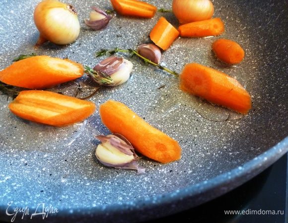 Чтобы приготовить «сумасшедшую воду», возьмем пару маленьких луковиц, мелкую морковку, тимьян, чеснок. На масле поджарим крупно нарезанную морковь, чеснок, раздавленный плоской стороной ножа, и луковки. Лук и чеснок можно не чистить!