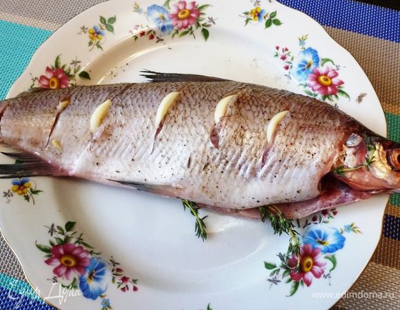 Рыбу почистим и хорошо вымоем, посолим и поперчим, сделаем надрезы по бокам и в каждый вставим пластинку чеснока. В брюшко вложим веточки тимьяна.