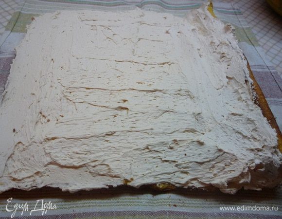 Разворачиваем рулет и смазываем полученным кремом. Аккуратно сворачиваем и даем пропитаться 20—30 минут. Оставляем немножко крема для украшения.