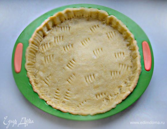 Достать тесто, поместить его между двумя слоями пленки и аккуратно раскатать в круглую тонкую лепешку. Традиционный американский тыквенный пирог с корицей выпекается в неглубокой форме с пологими краями диаметром примерно 23 — 24 см. С помощью пленки нужно аккуратно выложить тесто по форме, подравнять края, сформировать бортики, вилкой или пальцами делая защипы. В нескольких местах наколоть основу вилкой.