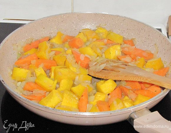 Добавить к луку нарезанную крупными кубиками тыкву и морковь. Помешивая, обжарить до мягкости.