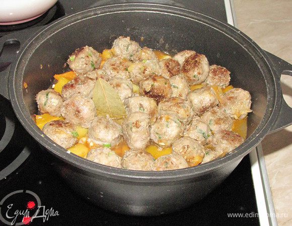 За 5 минут до готовности сверху выложить мясные шарики, один лавровый лист и измельченный чеснок, тушить под крышкой.