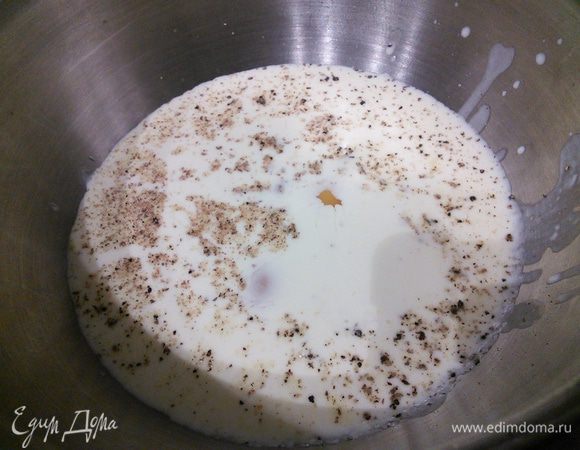 Теперь нам понадобится дуршлаг. Через него нужно слить сливки в миску, посолить и поперчить их, а также добавить щепотку мускатного ореха. Вбить яйца, разболтать и добавить половину натертого сыра. 