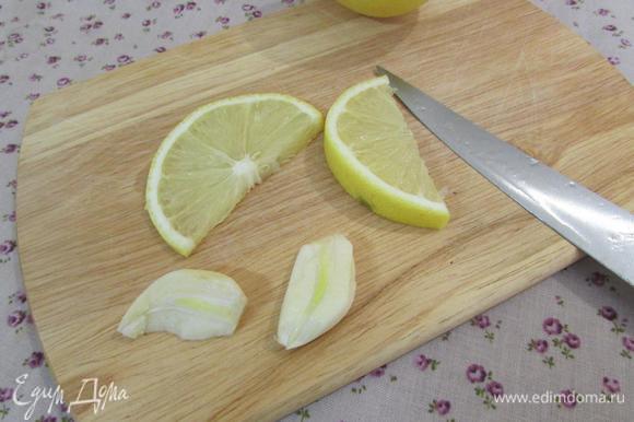 Зубчик чеснока почистить и разрезать вдоль на две пластинки. Ломтик лимона разрезать пополам.